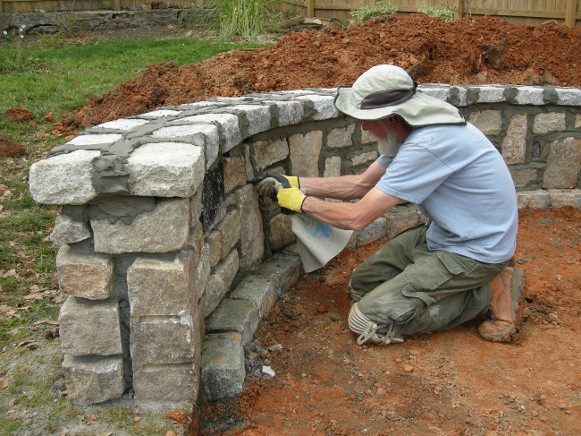 Ray adding the grout between the granite. They then went back and scraped it to create the finished look.