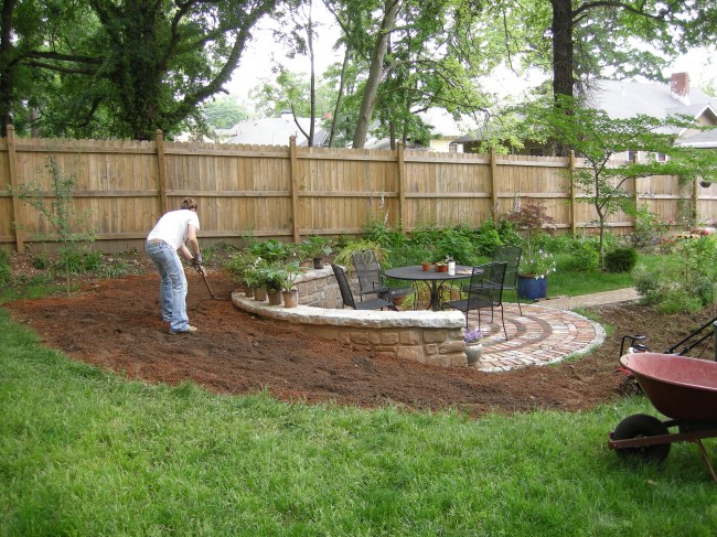 Steffi raking the dirt in the new flower bed.